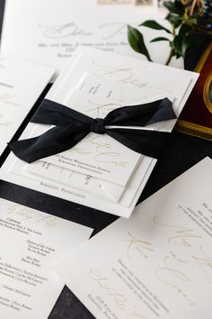 wedding stationery with black ribbon and gold calligraphy