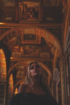 a woman standing in an ornate building with her eyes closed