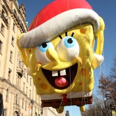 an inflatable spongebob balloon with a santa hat on it's head