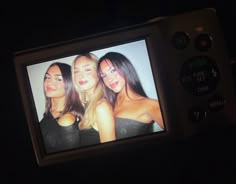 three beautiful women are on the screen of a cell phone