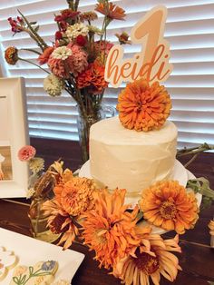 there is a cake and flowers on the table