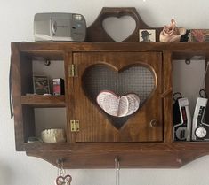 a wooden shelf with two heart shaped books and other items on it's shelves