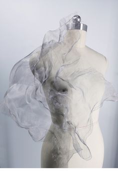 a white mannequin with sheer fabric on it