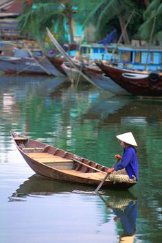 a person sitting in a small boat on the water