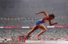 a woman is running on a track in the rain