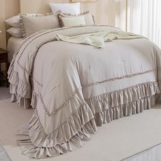 a bed with ruffled bedspread and pillows