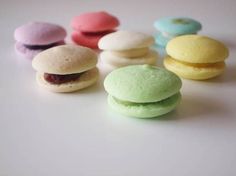 there are many different colored macaroons on the table with chinese characters in the background