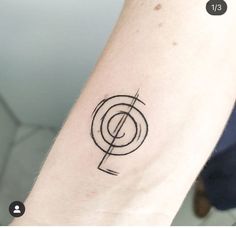 a black and white photo of a person's arm with a music note tattoo on it