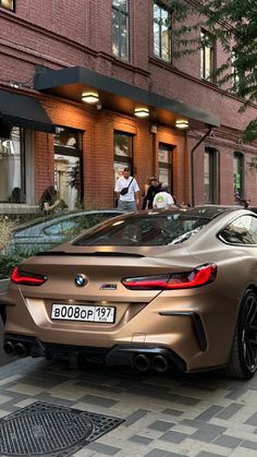 a car parked on the street in front of a building with people walking around it