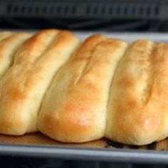 freshly baked bread rolls lined up on a baking sheet in the oven, ready to go into the oven