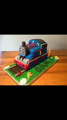 a thomas the train birthday cake on a wooden table