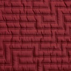 a red quilted material with small squares and lines on the bottom, as if it were made from fabric