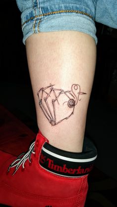 a woman's leg with a tattoo on it that has an image of a diamond in the shape of a heart