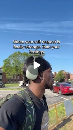 a man standing in front of a parking lot wearing headphones with a quote on it