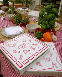 the table is covered with red and white napkins, vegetables, and other kitchen utensils