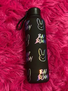 thermos bottle with bunny faces on it is laying on a pink fur covered surface