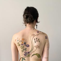 the back of a woman's body with flowers painted on it