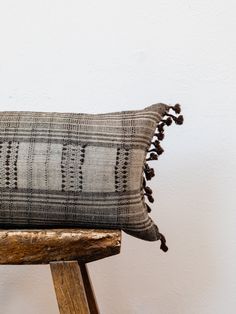 a black and white pillow sitting on top of a wooden chair