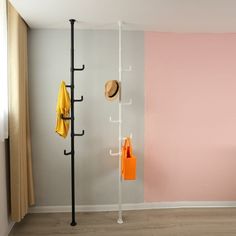 there is a coat rack with hats on it and two coats hanging up against the wall