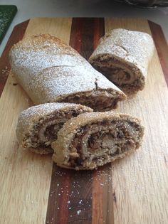 a wooden cutting board topped with two pieces of food covered in powdered sugar on top of it