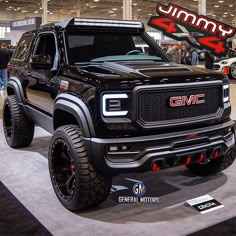 a black truck is on display at an auto show