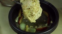 a chicken is being cooked in a pot with vegetables