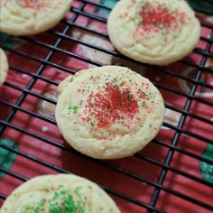 several cookies with sprinkles cooling on a wire rack in front of red and green napkins