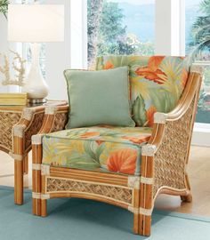 a wicker chair and table in front of a large window with flowers on it