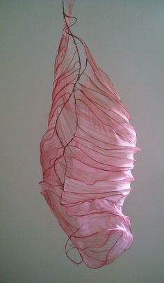 a pink piece of art hanging from the ceiling