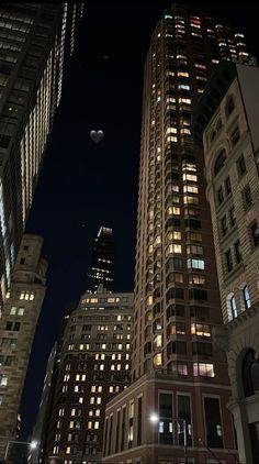 the city is lit up at night and there are many tall buildings in the background