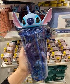 someone is holding up a cup with stitchon on it