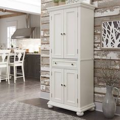 a tall white cabinet sitting in the middle of a living room