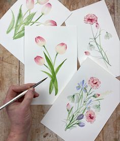 someone is painting flowers with watercolors on paper