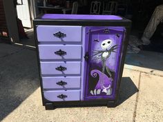 a purple and black dresser with a skeleton painted on it