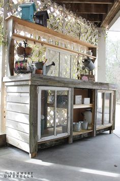 an outdoor bar made out of pallet wood and glass doors with plants growing on top