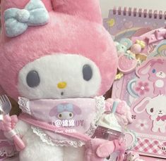 a hello kitty stuffed animal holding a baby cup and fork in it's hand