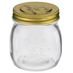 a glass jar with a gold lid on a white background, it is empty and has writing on the top