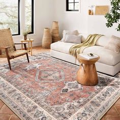 a living room filled with furniture and a large rug on top of a wooden floor