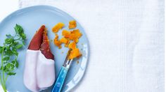 a blue plate topped with food next to a knife