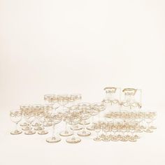 a bunch of wine glasses sitting next to each other on top of a white table