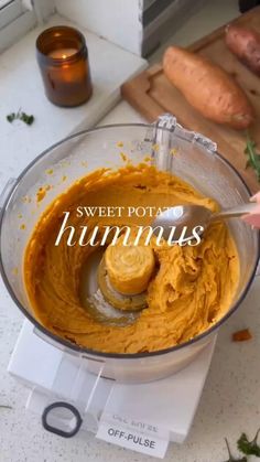 a food processor with sweet potato hummus in it