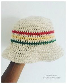 a white crocheted hat with red, yellow, and green stripes on the brim