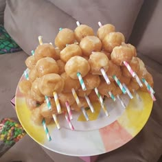 there are many donuts on the plate with paper straws sticking out of them