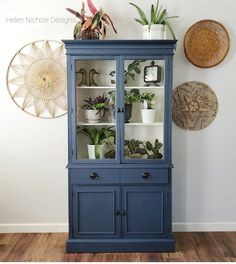 a blue china cabinet with plants on top