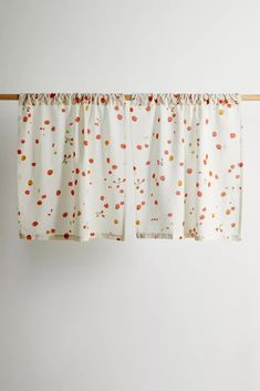 two curtains hanging on a clothes line in front of a white wall with polka dots