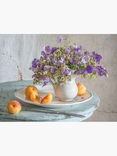 a white plate topped with purple flowers and peaches on top of a wooden table