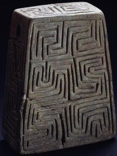 a stone block that has been carved into the shape of a square, with an intricate design on it