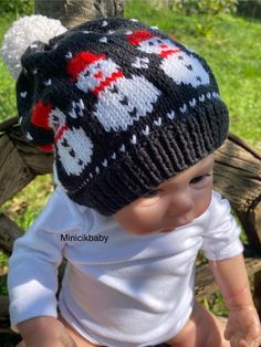 a baby wearing a knitted hat with skulls on it