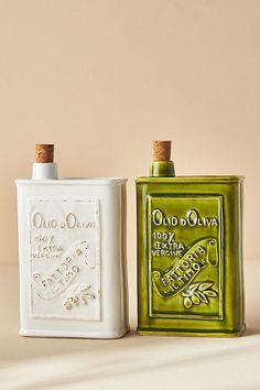 two old olive oil bottles sitting next to each other