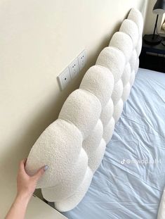 a person is placing pillows on the headboard of a bed that has been made into a pillow